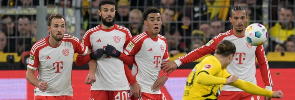 Hari Kejn, Nusair Mazraui, Džamal Musiala, i Liroj Sane pokušavaju da blokiraju pokušaj igrača Borusije Dortmund iz slobodnog udarca