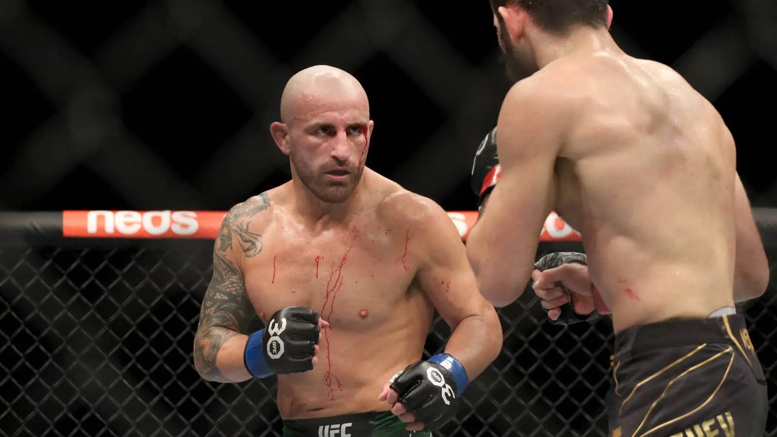 Islam Makhachev (red gloves) fights Alexander Volkanovski (blue gloves) during UFC 284 at RAC Arena