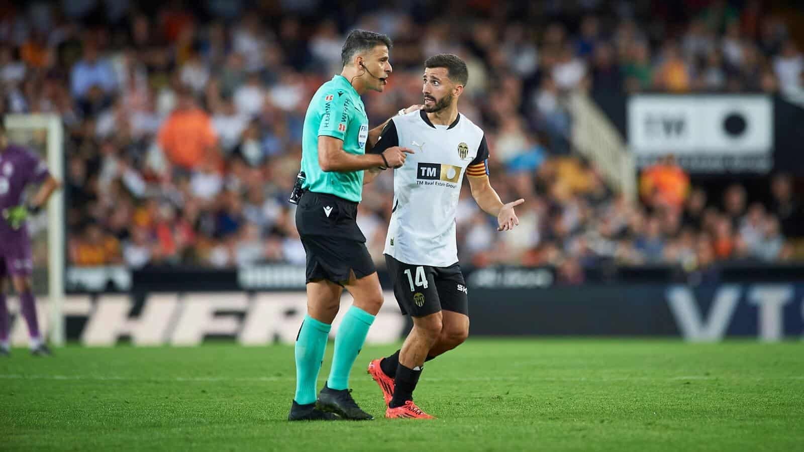 Jesus Gil Manzano referee (L) and Jose Gaya of Valencia CF (R) in action
