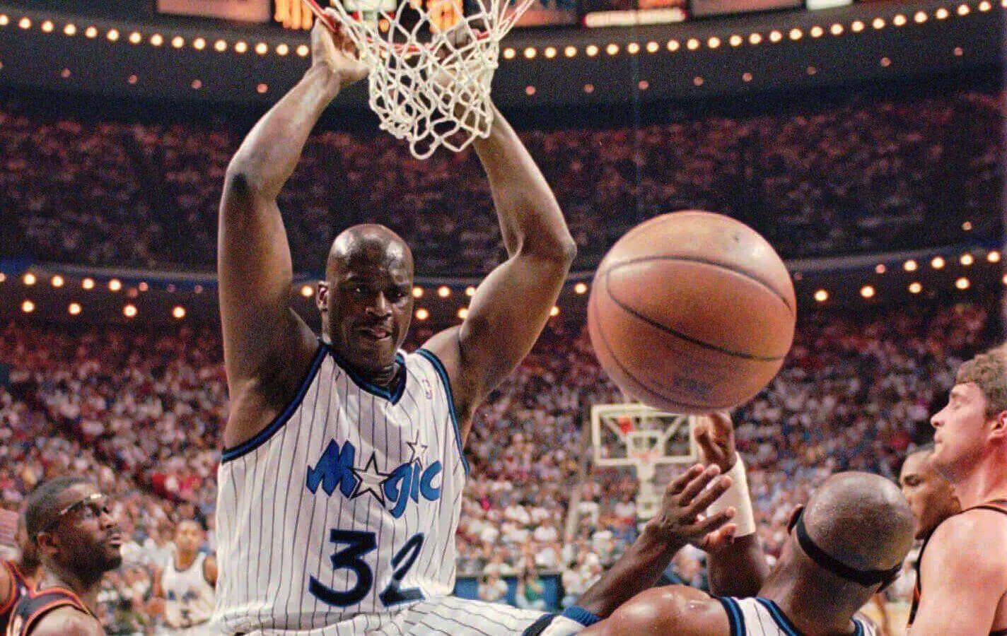 Shaquille O'Neal (32) hangs onto the rim after a powerful slam dunk